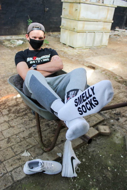 nahaufnahme einer weissen socke von unten der sk8erboy jubiläums socken 20 jahre smelly socken von einem jungen gay getragen der in einer schubkarre sitzt auf einem hof als limited edition