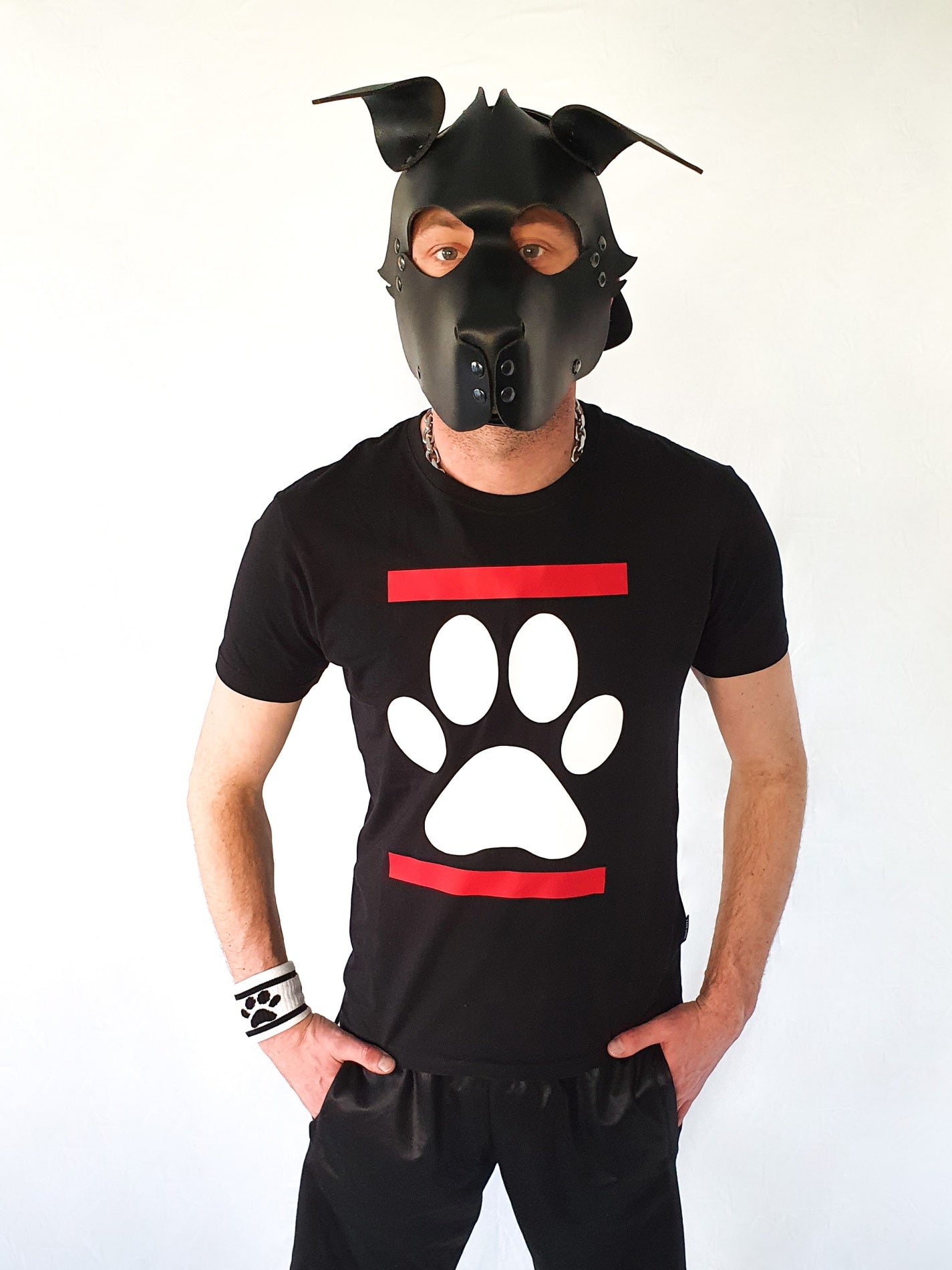 junge mit hundemaske aus leder und schwarzem sk8erboy dog paw t-shirt mit weisser hundepfote und shiny jogging hose vor weissem hintergrund