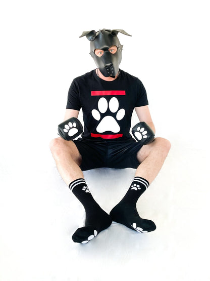 niedlicher sexy junge traegt eine leder hundemaske von mister b und das passende sk8erboy dog paw t-shirt in schwarz mit großer weisser hundephote zu seiner shiny short und die passenden schwarzen sk8erboy puppy socks mit pfote auf der seite und unterseite der socken