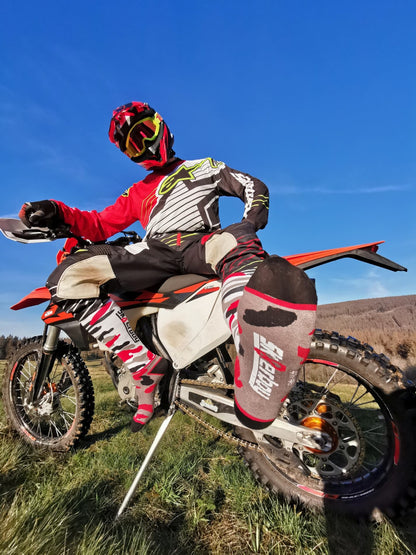 cross motor biker auf einer mx cross maschine auf dem feld mit helm und mx cross socks von sk8erboy in flecktarn mit grauer sohle und sk8erboy logo