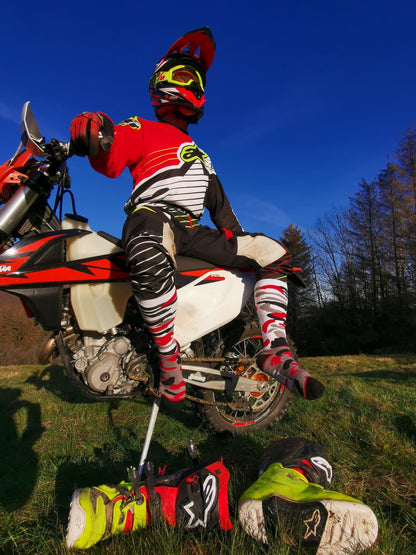 biker genießt die sonne auf seinem motorrad mit ausgezogenen stiefel und den mx cross socks von sk8erboy in flecktarn muster gegen flecken auf deinen liebsten socken