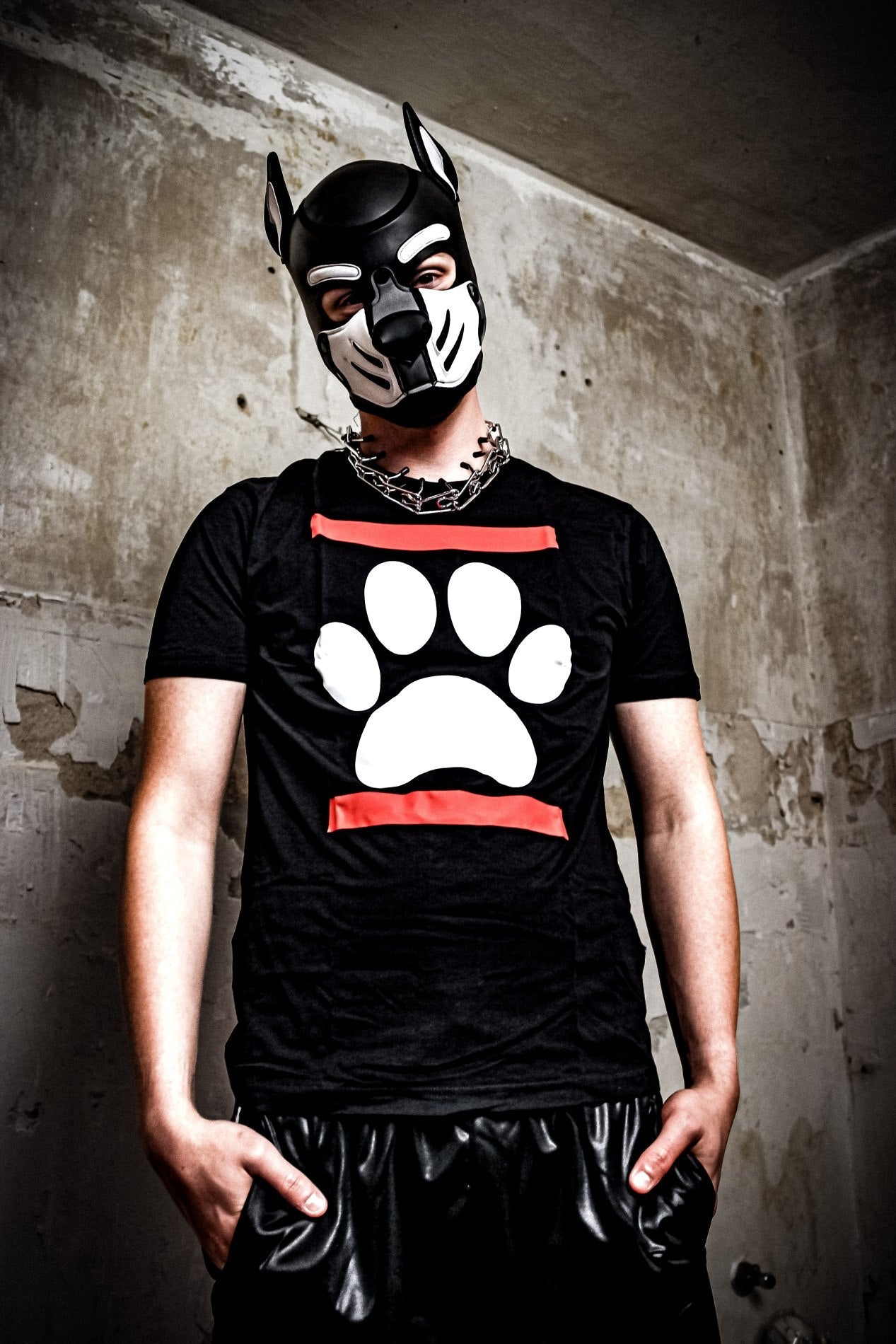 junge mit großer halsketter traegt eine hundemaske von mister b aus leder mit schwarzem sk8erboy dog paw puppy t-shirt mit einer weissen hundephote zwischen zwei roten balken und eine bequemen sk8erboy shiny trainingshose