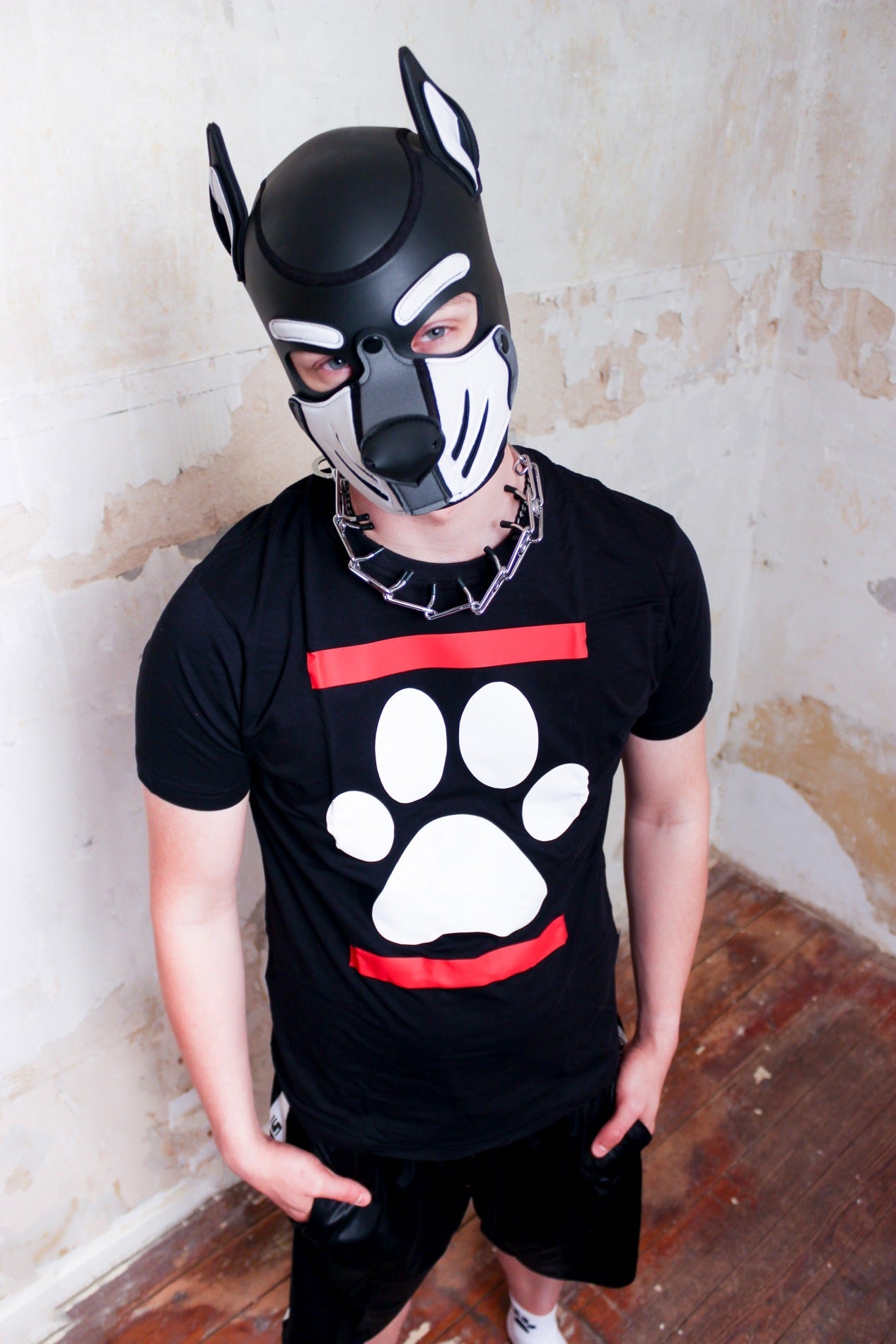 junge mit großer halsketter traegt eine hundemaske von mister b aus leder mit schwarzem sk8erboy dog paw puppy t-shirt mit einer weissen hundephote zwischen zwei roten balken und eine bequemen sk8erboy shiny trainingshose