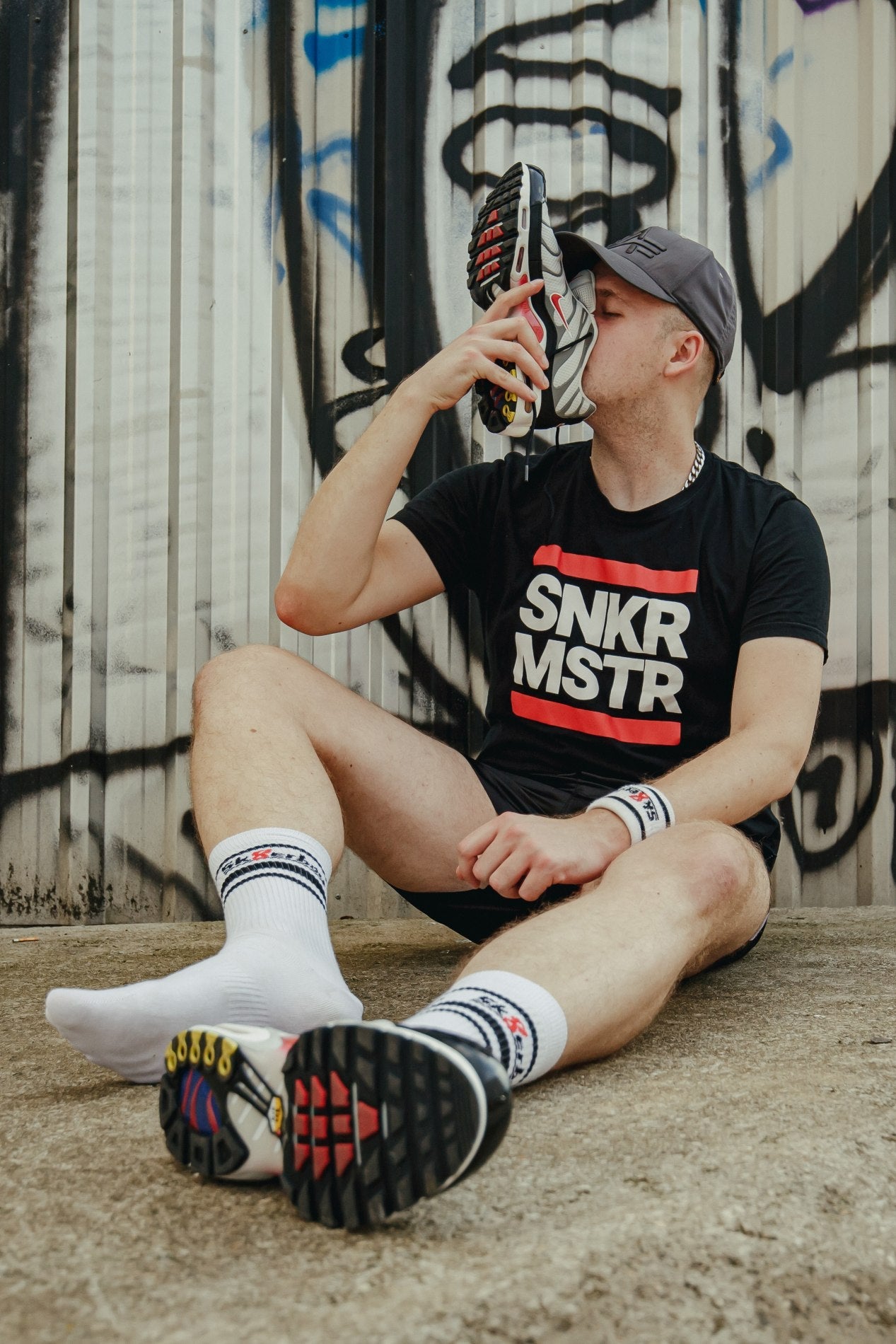 sk8erboy victory socken extra dünn in bekannter qualität jedoch besonders leicht und ideal für den sommer in weiss getragen von einem jungen gay der an seinen nike tn sneakern snifft und auf dem boden sitzt